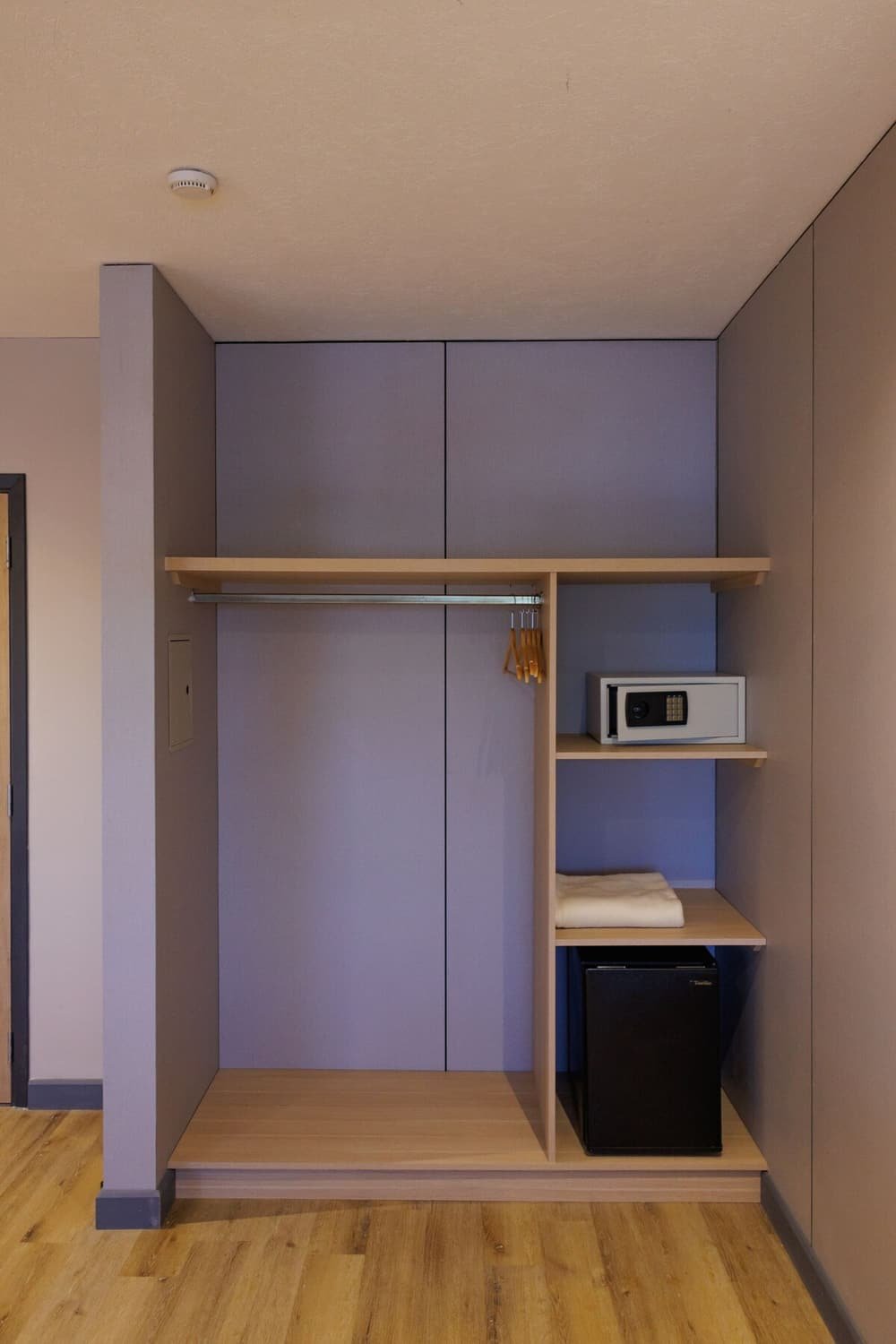 Quarto moderno com armário embutido, micro-ondas e frigobar pequeno