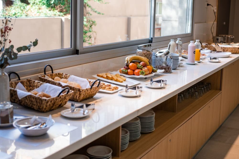 Buffet de café da manhã com variedade de alimentos e condimentos