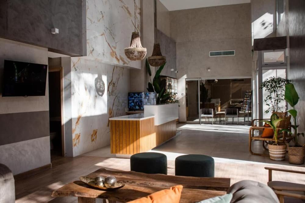 Sala de estar ampla com mesa de centro de madeira e televisão na parede