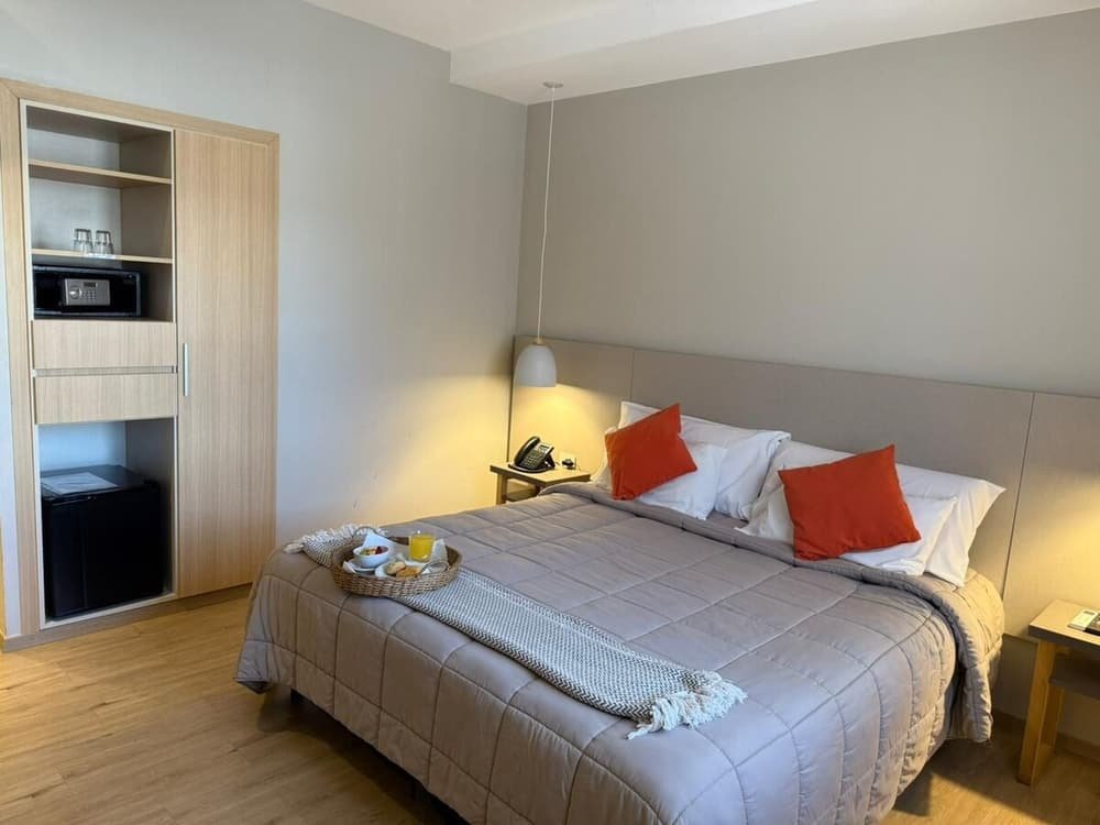 Quarto com cama, criado-mudo, armário e bandeja de café da manhã