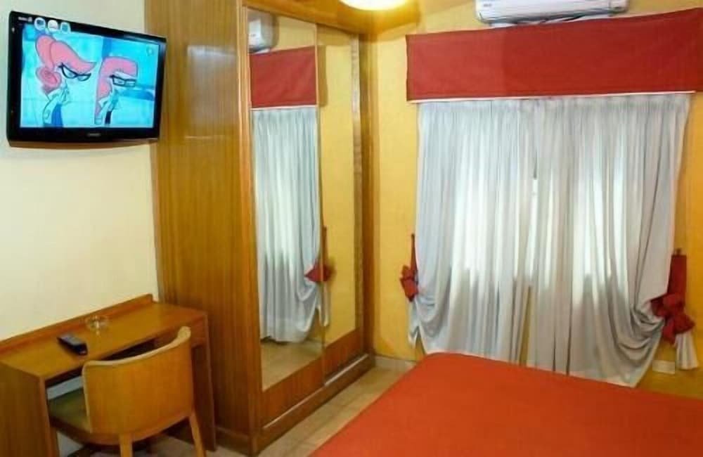 Hotel room with two beds, a wooden headboard and a framed picture