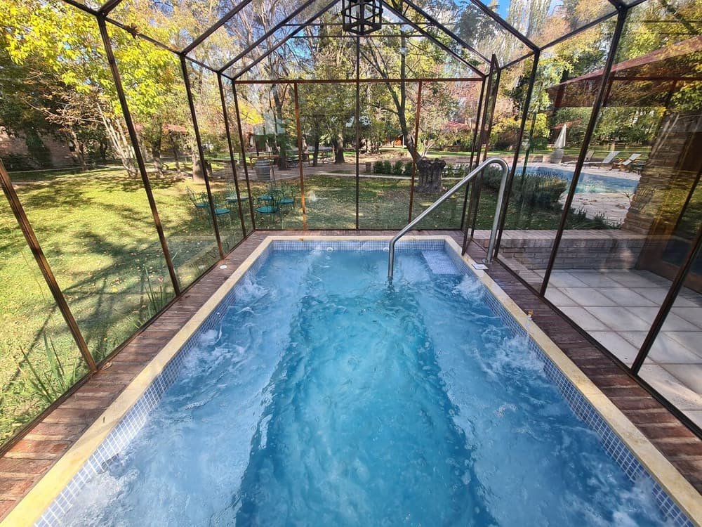 Jacuzzi rectangular al aire libre sobre una tarima de madera con jardín