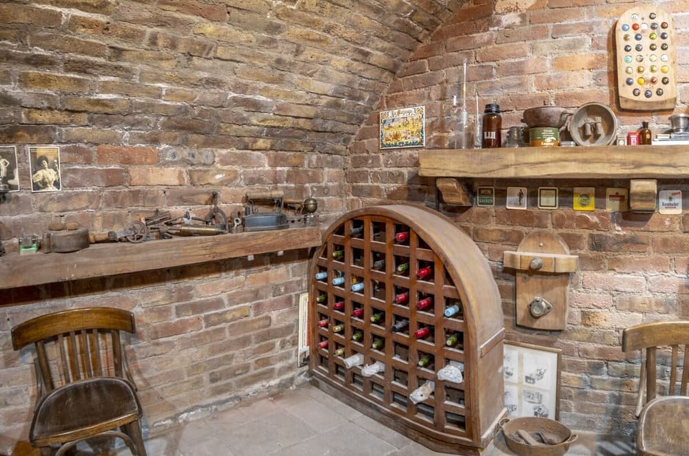Cava rústica con paredes de ladrillo, estantes de madera y botellero
