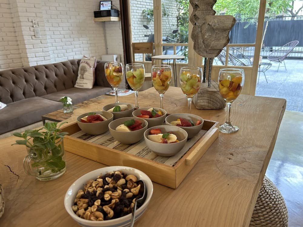 Mesa de madera con frutas, vasos de ponche de frutas y frutos secos