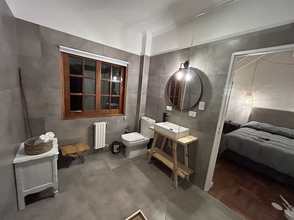 Baño compacto con inodoro, lavabo y una ventana pequeña