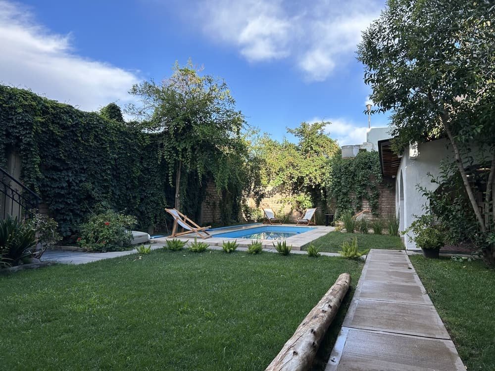 Jardín trasero con piscina, deck de madera y césped