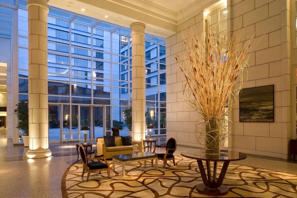 Lobby amplo e moderno com parede de vidro, estar central e vaso decorativo