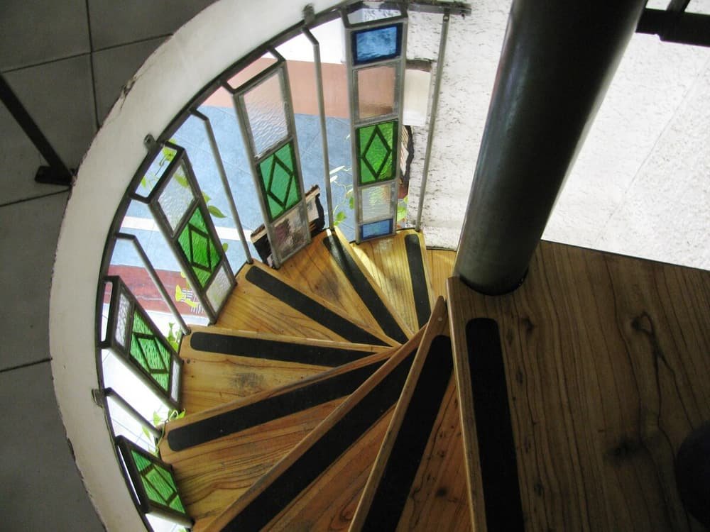Escalera caracol con escalones de madera y barandas de vidrio