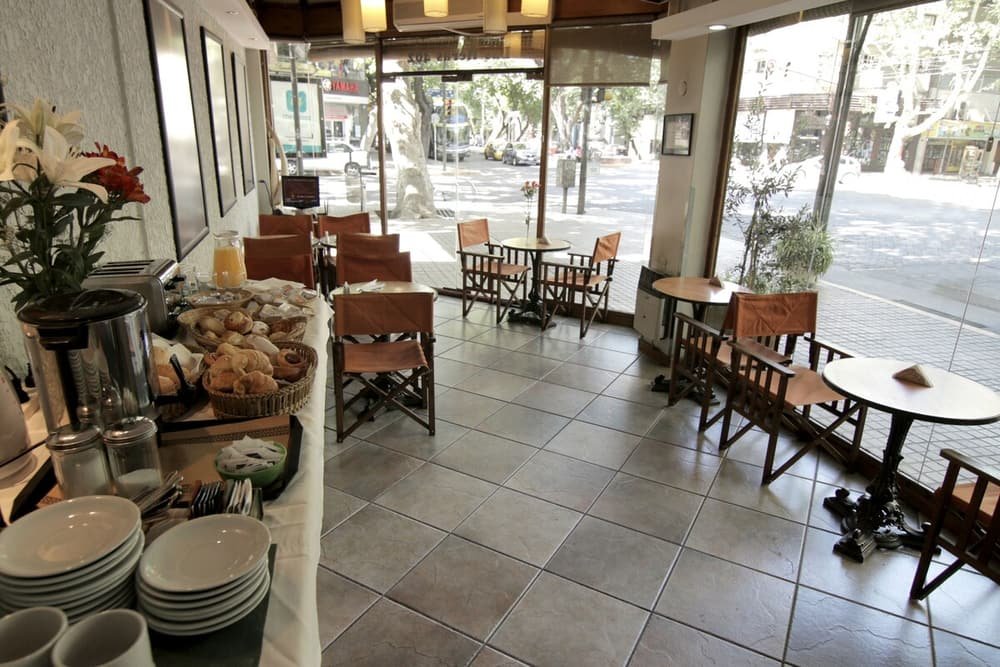 Restaurante con mesas al aire libre, variedad de platos y vista a la calle